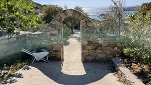 Ein steiner Torbogen, der zu einem Weg mit Blick auf das Meer führt.