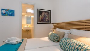 Une chambre d’hôtel avec un lit, une salle de bain et un tableau au mur.