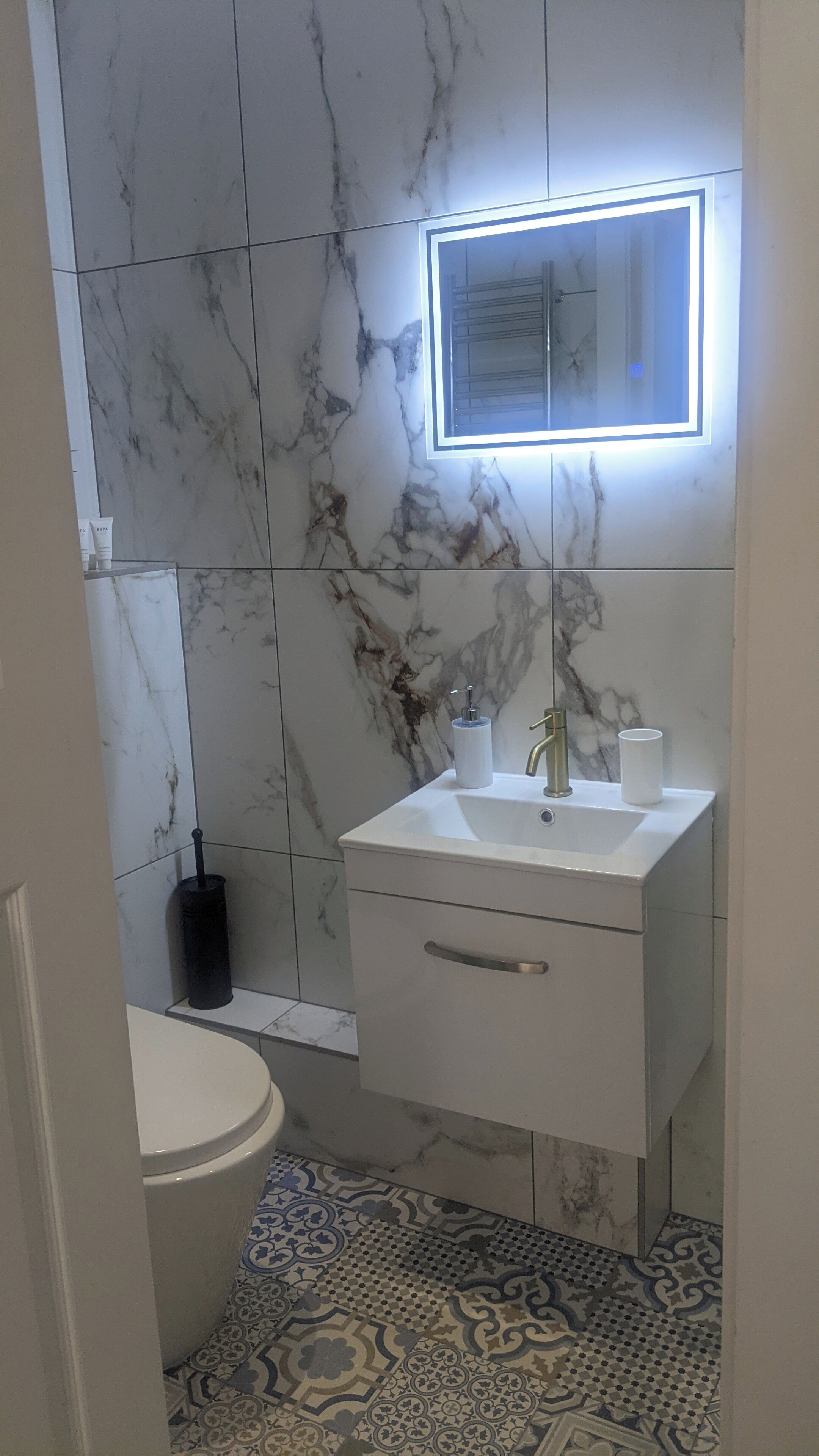 A bathroom with a white sink, a mirror, and a toilet.