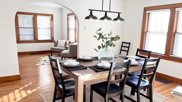 A dining area with a wooden table, black chairs, and a modern pendant light. - Peaceful & Clean Getaway/3BR-By KWU & DnTown (Salina)
