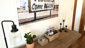 A 'THANKS Come Again' sign, a wicker basket with items, a potted plant, and a light fixture. - Peaceful & Clean Getaway/3BR-By KWU & DnTown (Salina)