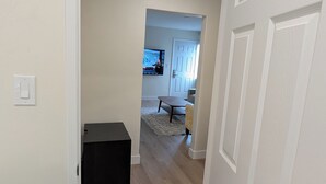 A hallway leading to a living area with a television, a sofa, and a coffee table. - Rest Haven Motel (Santa Monica)