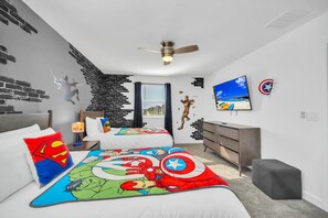 A bedroom with two beds, a ceiling fan, a TV, and a window with curtains.