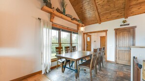A dining area with a wooden table and chairs, a window with curtains, and a wooden ceiling. - Water-View Home Half Mile to Table Rock Lake (Green Forest)