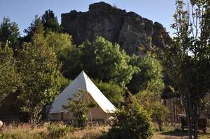 A tented accommodation with a view of a large rock formation.