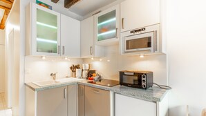 A modern kitchen with white cabinets, a built-in microwave, and a toaster. - Parisian Pied-a-terre in the heart of the city - Close to everything (Paris)