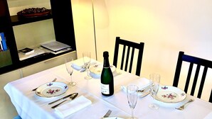 A dining table set with plates, cutlery, a wine bottle, and a lamp. - Parisian Pied-a-terre in the heart of the city - Close to everything (Paris)