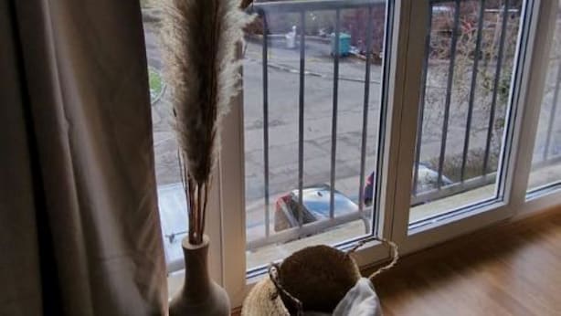 A room with a large window, a vase with dried pampas grass, and a woven basket on the floor. - K190 - 2BDR Apartment close to Zurich Airport (Zürich)