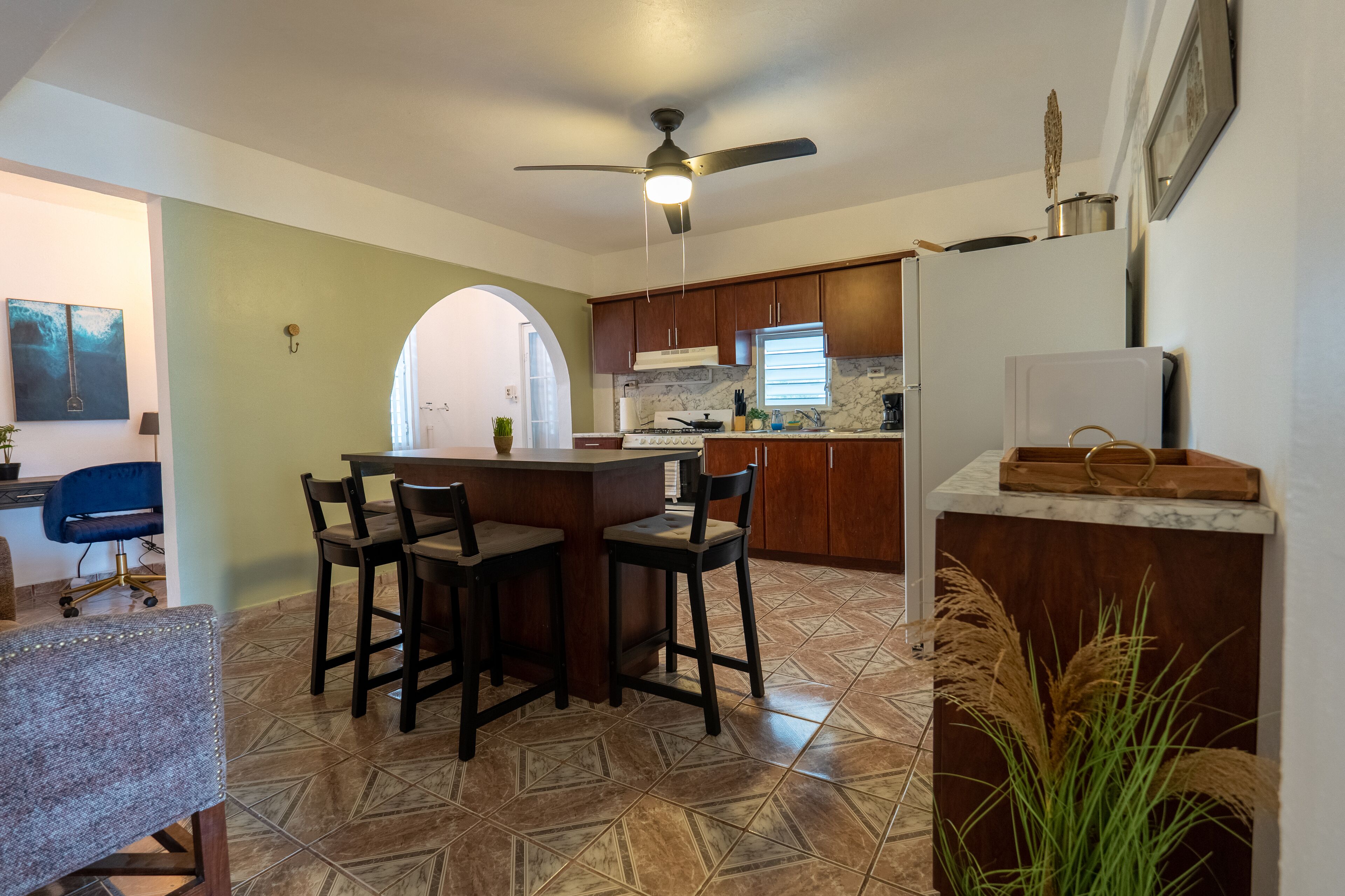 Una cocina con comedor, ventilador de techo y encimera de mármol.