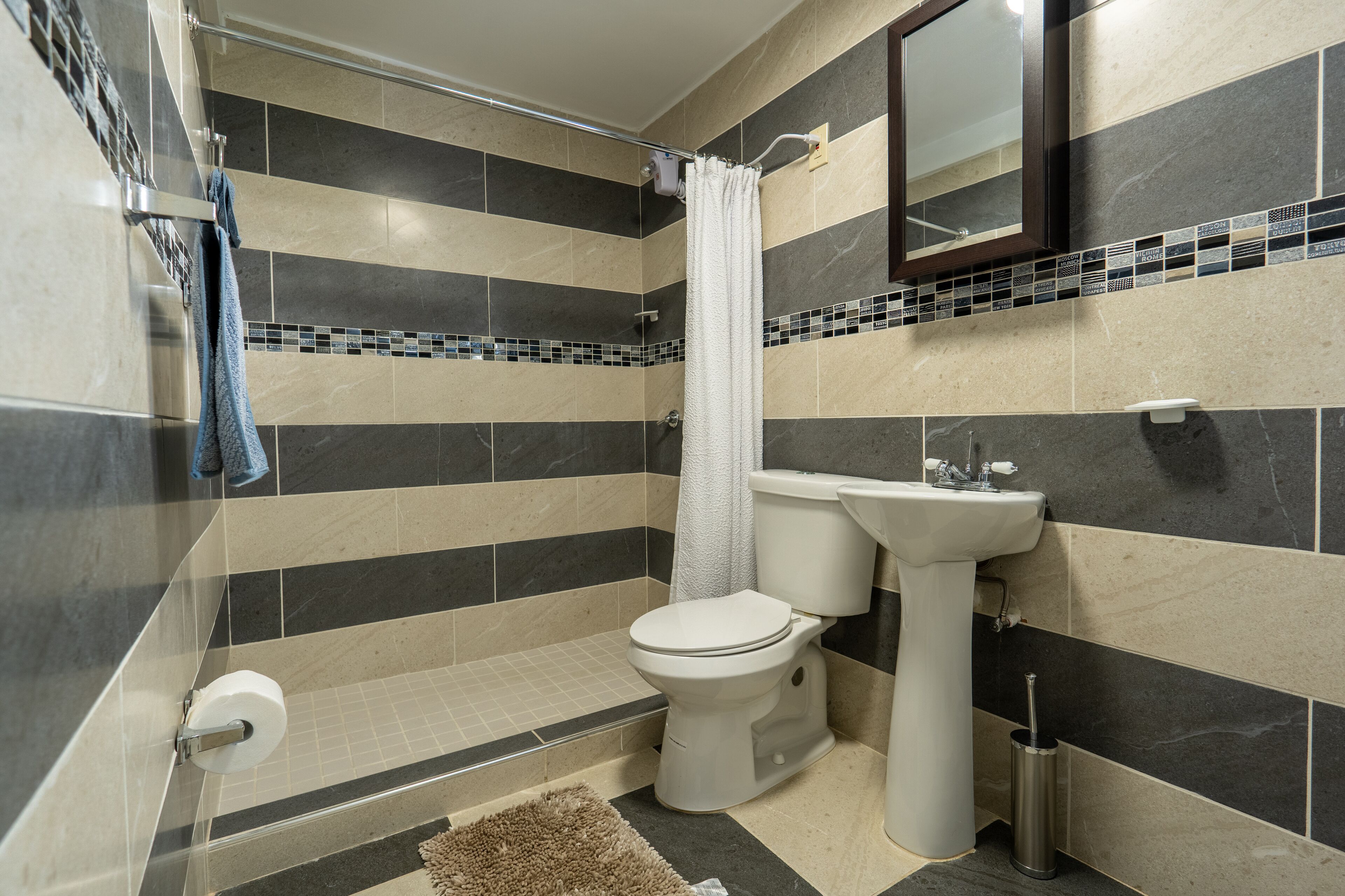 Une salle de bain moderne équipée d’une douche, de toilettes et d’un lavabo.