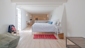 A bedroom with a white bed, a red rug, and a wooden chair. - Quinta do Pinhô - Tarouca (Tarouca)
