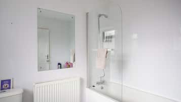 A bathroom with a white radiator, a mirror, and a glass-enclosed shower.