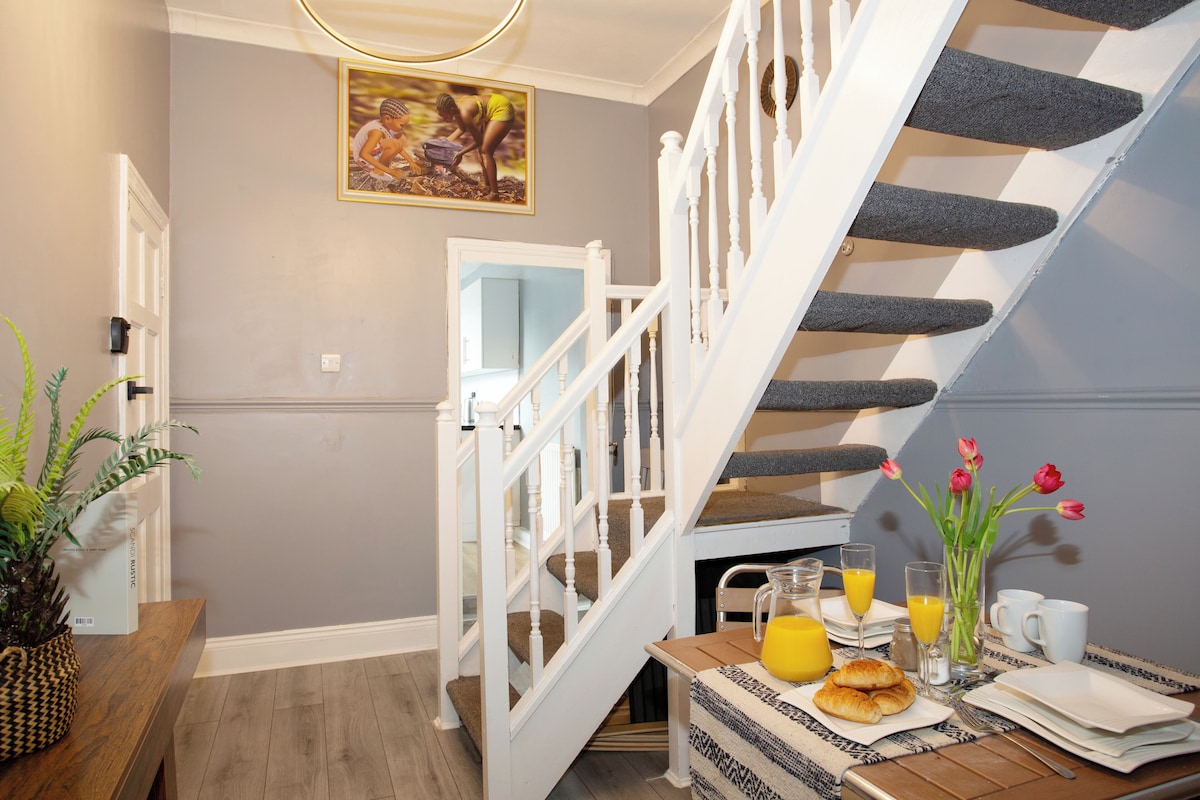 A staircase with white balusters, a dining area with breakfast items, and a wall-mounted picture.