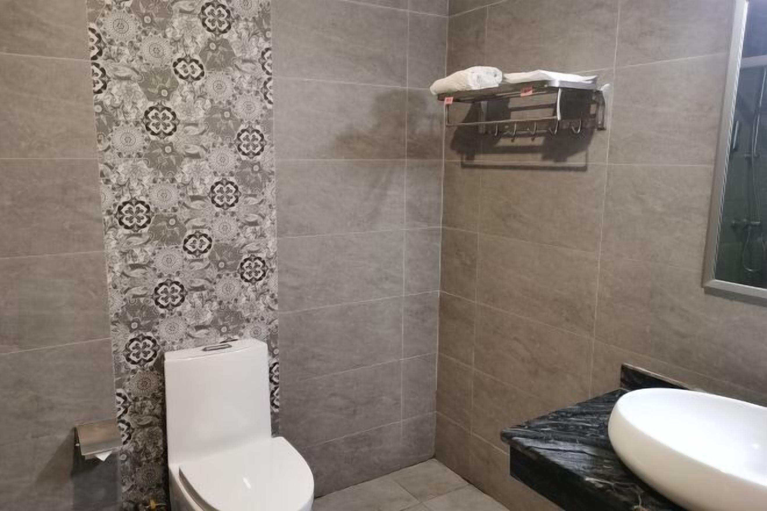 A bathroom with a toilet, a sink, and a towel rack.