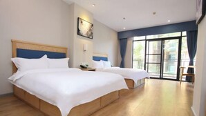 A hotel room with two beds, wooden headboards, a large window with curtains, and a view of the outdoors. - Fuxin Inn (Zhuhai Baitengtou ) (Zhuhai)
