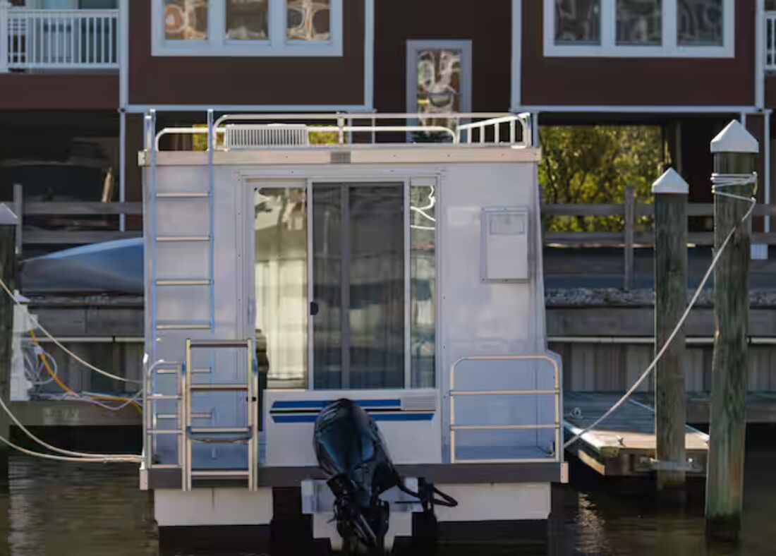 Un bote estacionado con cabina, ventanas y una escalera.