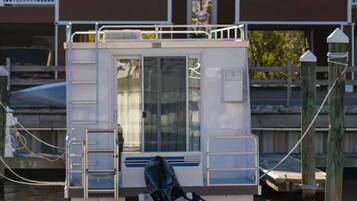 Un bote estacionado con cabina, ventanas y una escalera.