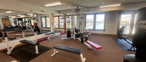 A gym with various exercise equipment, including treadmills, weight machines, and benches.