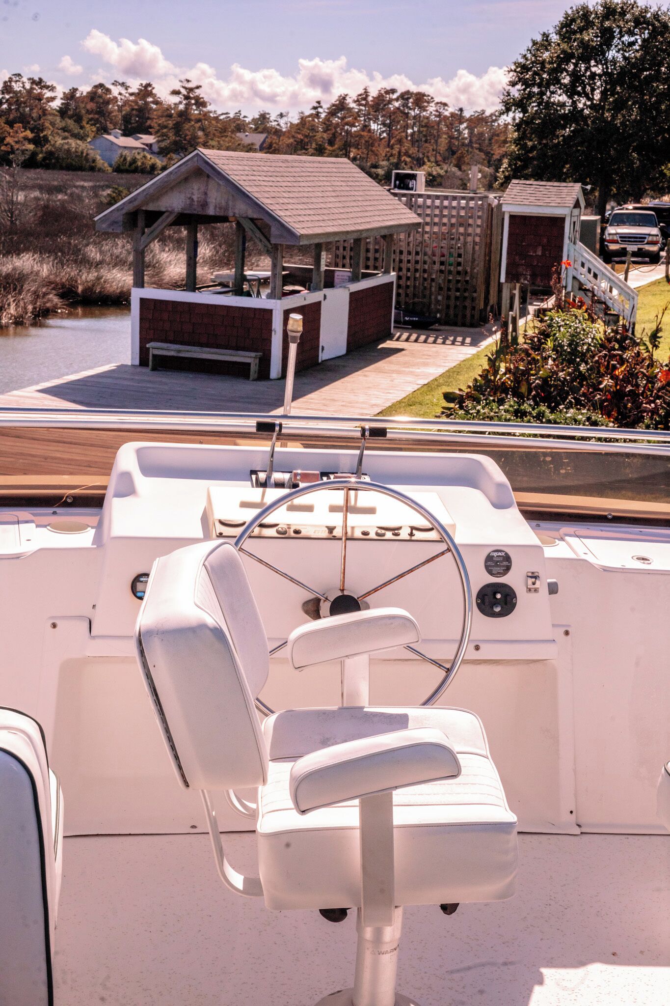 L'intérieur d'un bateau, avec un volant, un siège rembourré et un panneau de commande.