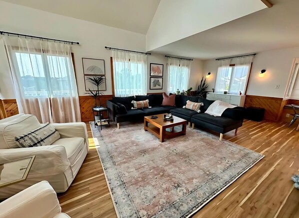 A living room with a sofa set, a coffee table, and a rug.