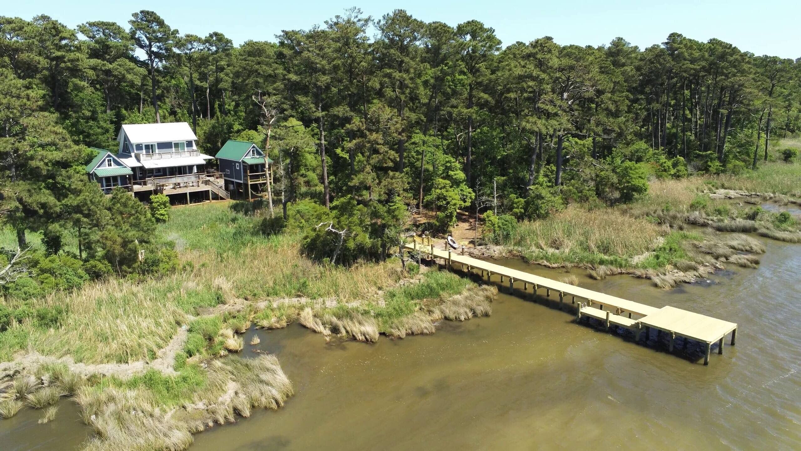 A house with a deck and a bridge over a river.