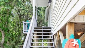 A set of outdoor wooden stairs leading up to a house.