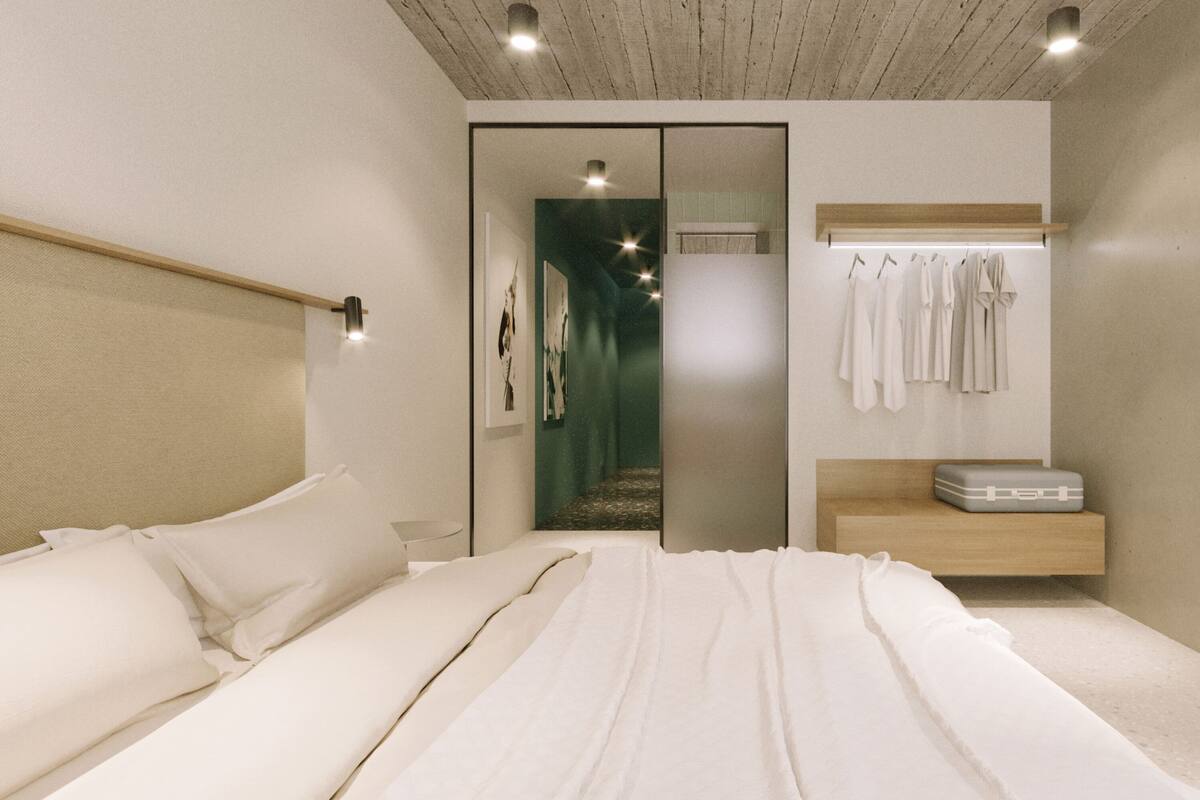 A bedroom with a bed, a bedside table, a wardrobe, and a mirror.