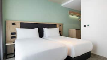 Habitación doble con dos camas, cabecero de madera, mesitas de noche y estante empotrado.