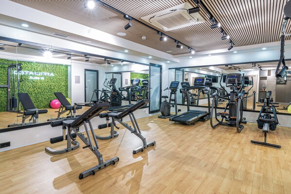 A modern gym with cardio machines, weight stations, and a green wall. - Hotel Levante St. Julian's, Affiliated by Meliá (St. Julian's)