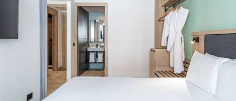 A hotel room with a bed, a wardrobe, a mirror, and a television.