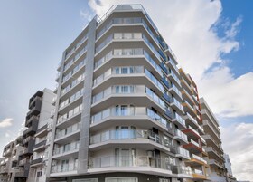 Un hotel de varios pisos con balcones, ventanas amplias y un diseño arquitectónico moderno.