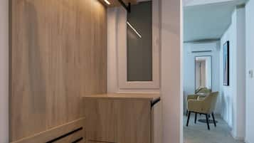 A modern, minimalist room with a wooden bench, a mirror, and a chair.