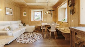 Ein gemütliches Holzambiente mit einem weißen Sofa, einem Holzesstisch und Stühlen.