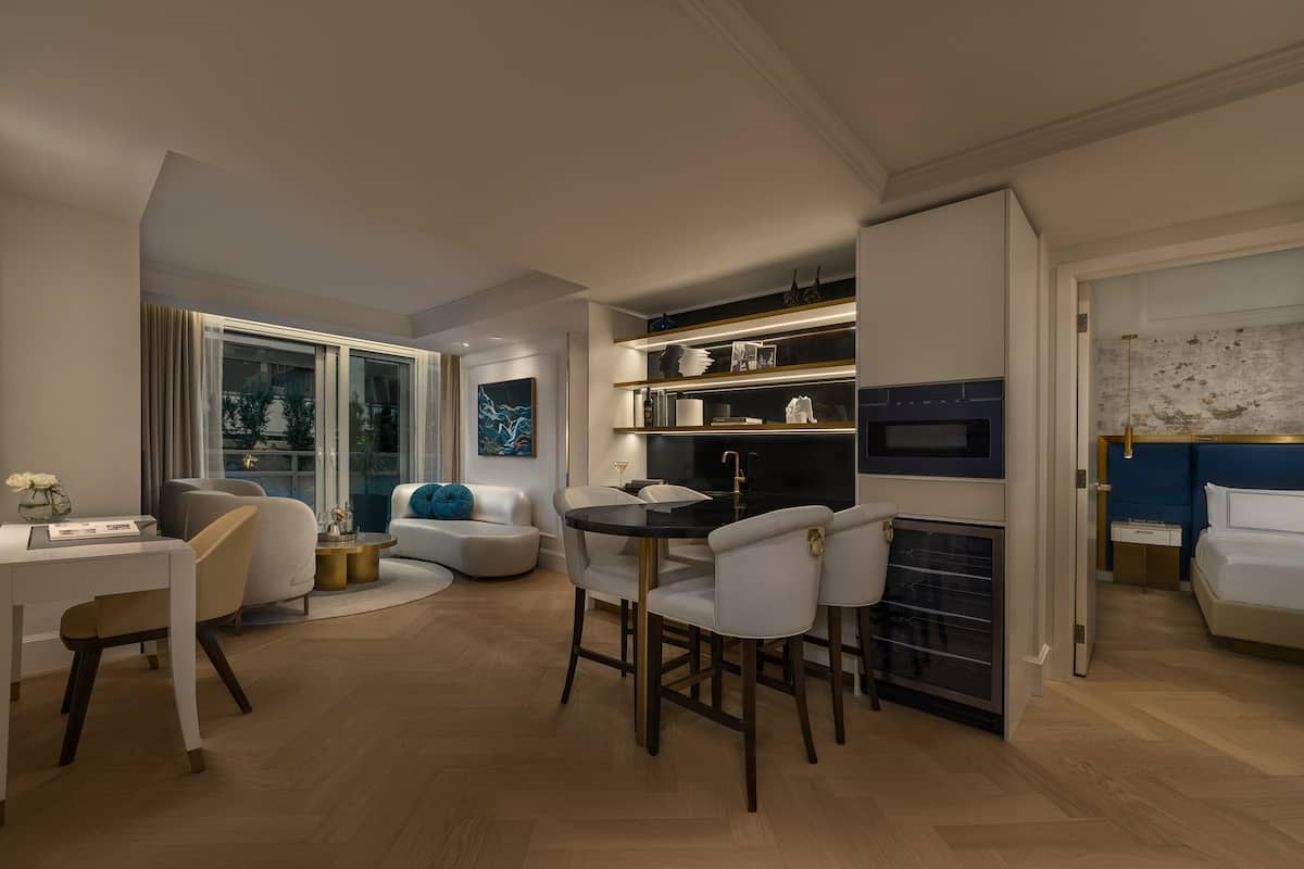 A modern living room with a dining area, a fireplace, and a kitchen with built-in appliances.