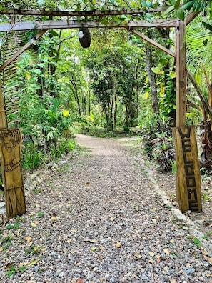 Una pérgola de madera con un camino de grava que atraviesa un jardín.