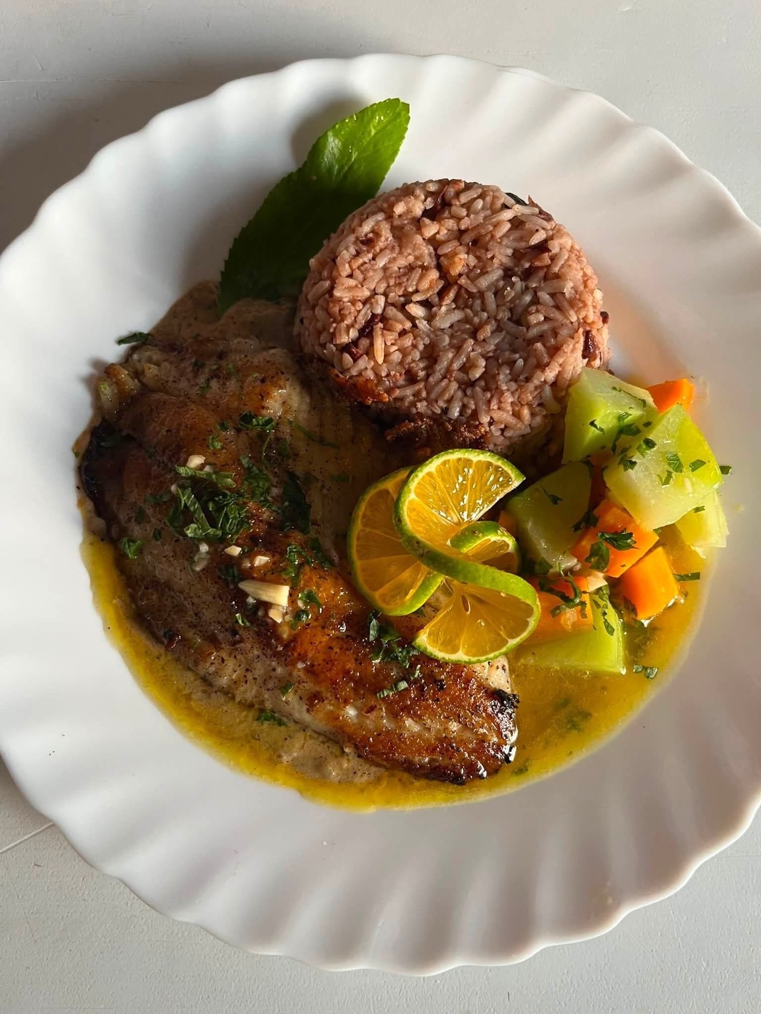 A plate with a fish fillet, a mound of rice, and a side of vegetables.