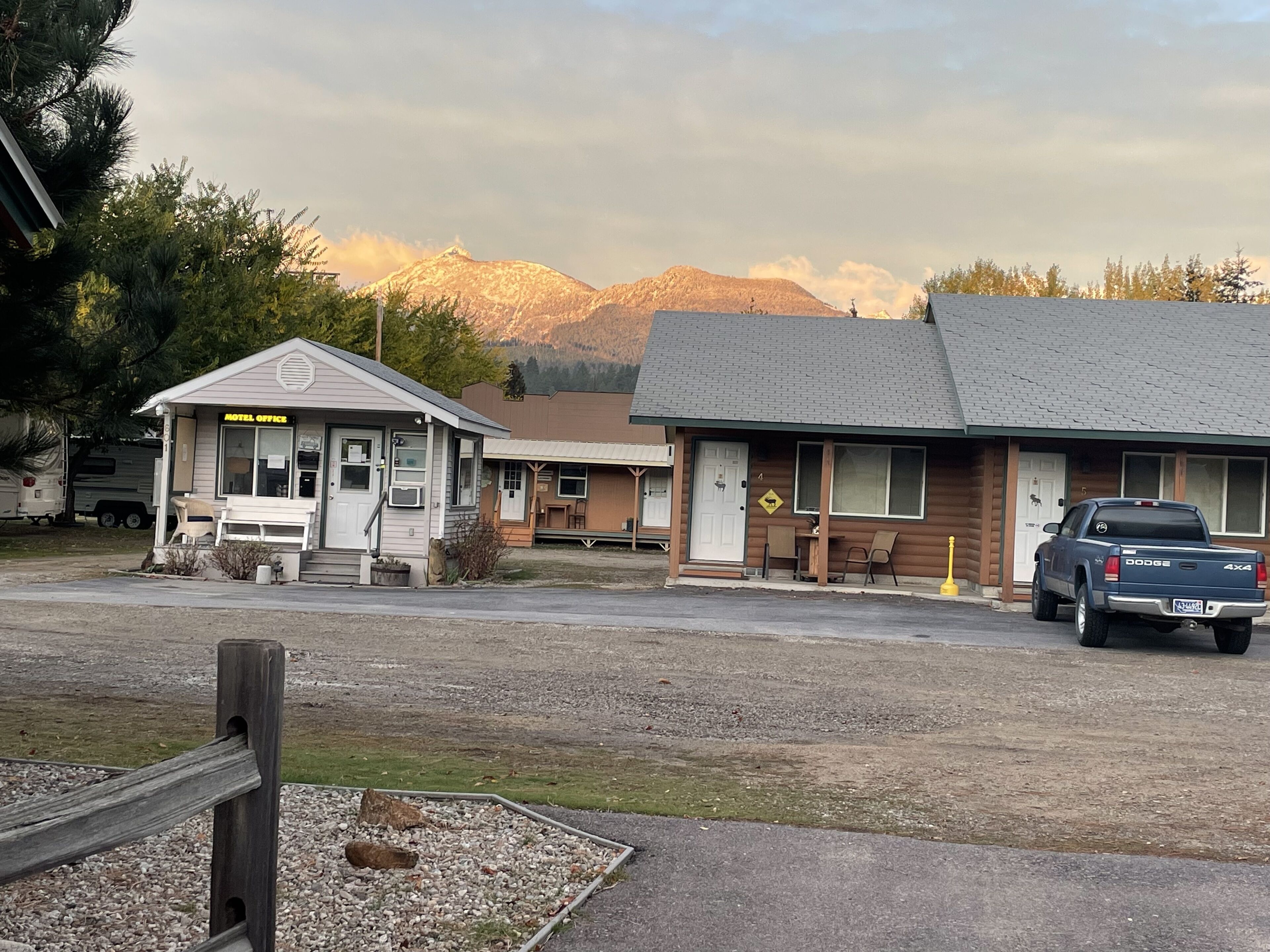 Un motel comprenant un petit bureau, un espace repas et un parking.