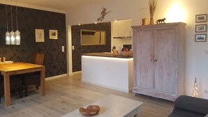 Une cuisine moderne dotée d’un îlot central, d’une table à manger en bois et de chaises.