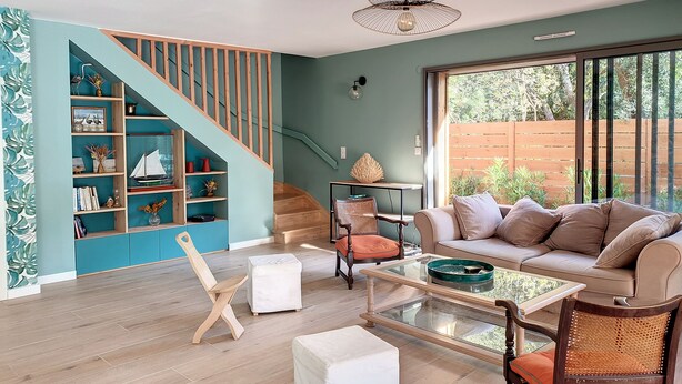 A modern living room with a staircase, a sofa, a coffee table, and a bookshelf. - 50 m from the lake, new wooden house - ideal family (Lacanau)
