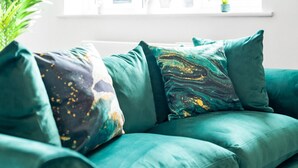 Ein blaugrünes Sofa mit zwei Zierteilen.