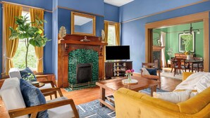 Una sala de estar con chimenea, televisor y comedor.