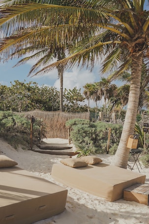Playa privada, arena blanca, sillas reclinables de playa, sombrillas. Astral Tulum
