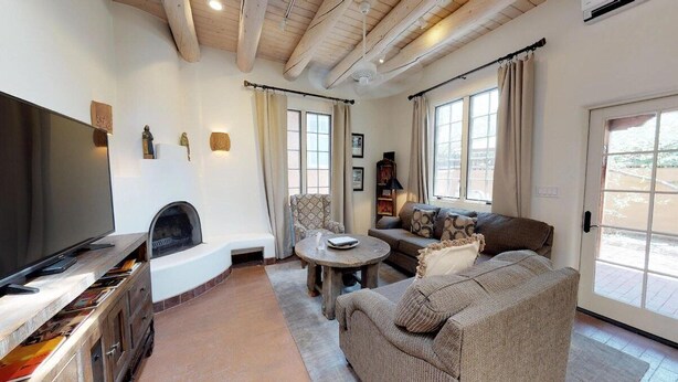 Una sala de estar con chimenea, sofá, televisor y comedor.