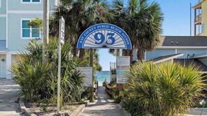 A pathway leading to a beach entrance with a sign indicating Bay County Public Beach Access.