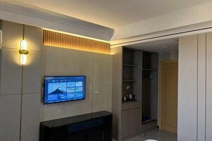 Un baño moderno con tocador, espejo y un televisor empotrado mostrando un mapa.