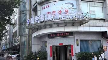 A building with a curved facade, a large sign with Chinese characters, and a closed entrance.