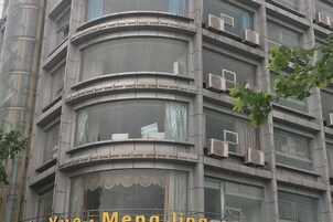 Un edificio de varios pisos con balcones y unidades de aire acondicionado.
