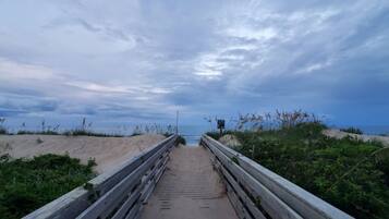 Ein Weg zum Strand mit Holzgeländer an beiden Seiten.