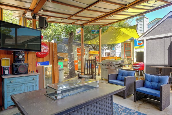 Un patio al aire libre con una parrilla, asientos y varios letreros.