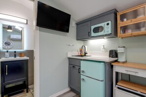 A compact kitchen with a microwave, a coffee maker, and a small refrigerator.
